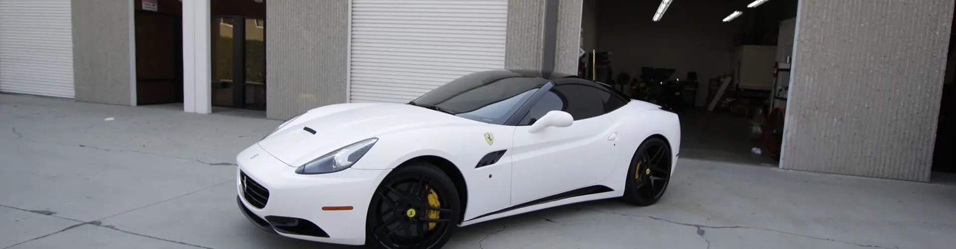 A white ferrari parked in front of a building.